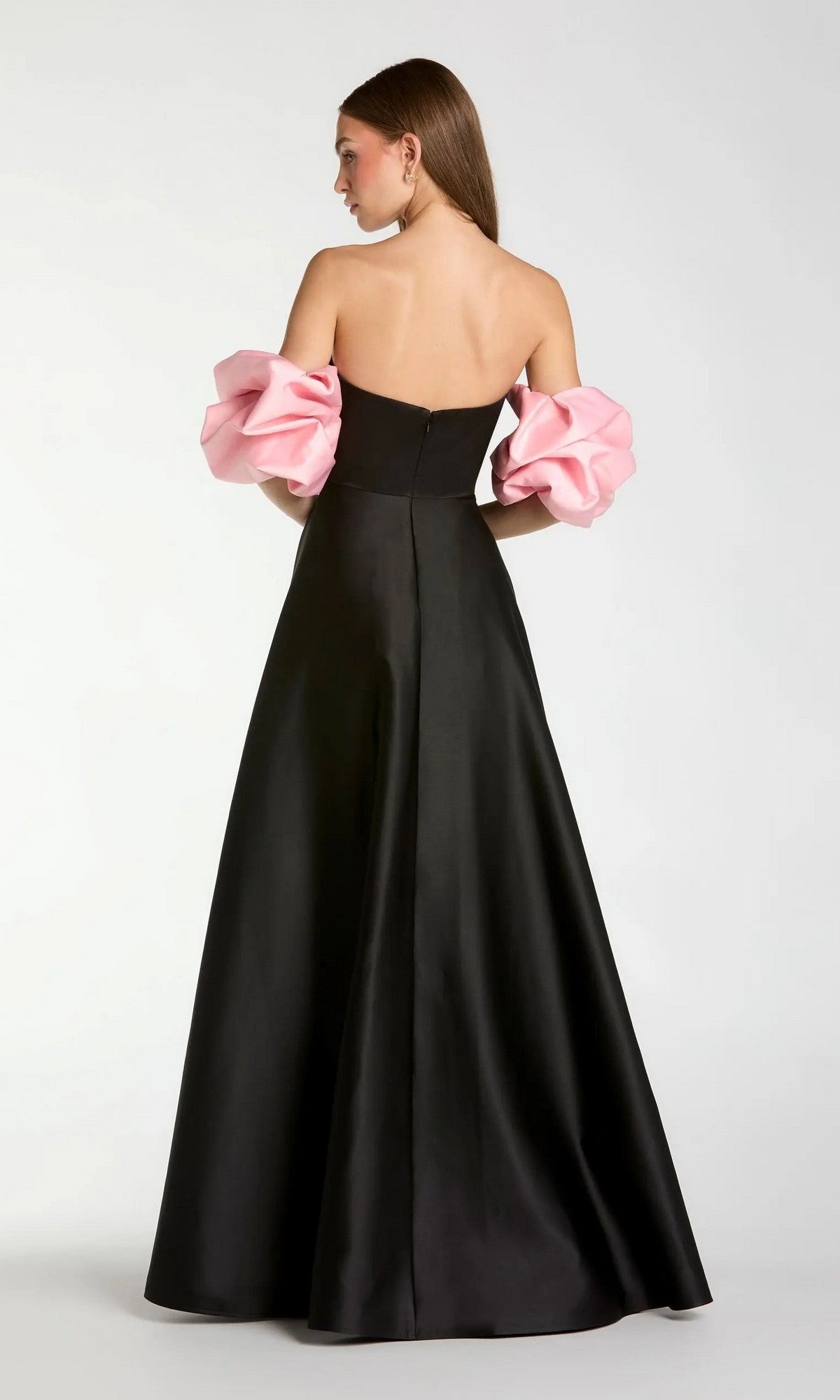 A woman is shown from the back wearing the Mac Duggal 21241 long formal dress—a black strapless satin gown featuring voluminous pink sleeves.